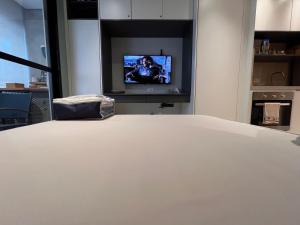 una mesa blanca con TV en una habitación en Studio ANHANGABAÚ, en São Paulo