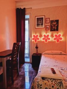 a bedroom with a bed and a desk and a window at Casa de Huespedes Dolce Vita in Madrid