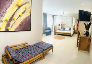 Le Lodge des Almadies في داكار: غرفة معيشة مع أريكة ولوحة على الحائط