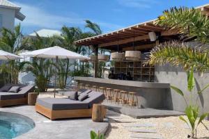 eine Terrasse mit Sofas und Stühlen sowie einem Pool in der Unterkunft Modern house with océano view in Belize in San Pedro