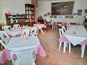 a restaurant with white tables and white chairs at Agricola Baldo e Riccia - Fattoria e Agriturismo in Perugia