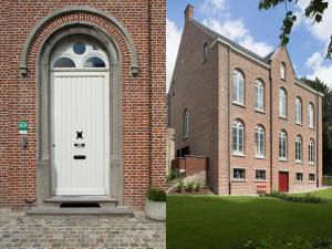 a door with a face on it in front of a brick building at B&B Pastorie Balegem in Balegem