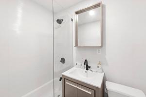 a bathroom with a sink and a mirror and a shower at 69-2C Brand New PRIME Lower East Side 1br Apt in New York