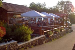 a group of people sitting at a bar with umbrellas at Gasthof Einfalt in Grossgerungs