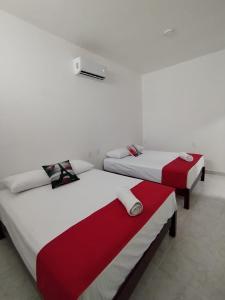 two beds in a room with white walls at Hotel Cermar Plaza in La Barca