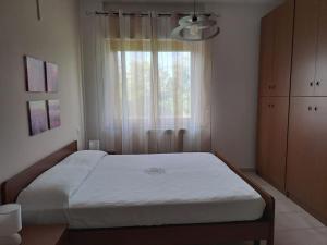 a bedroom with a large bed with a window at Appartamento Rossana - Luni (SP) in Marinella di Sarzana