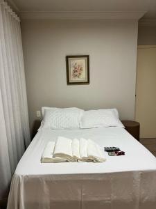 uma cama com duas toalhas e um livro sobre ela em Casa com churrasq, piscina e Wi-Fi em Criciuma SC em Criciúma