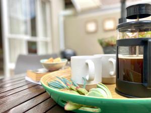 einen Tisch mit einer Tasse Tee und einem Teller Essen in der Unterkunft Willows Garden Cottage in Pretoria