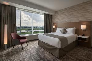 a hotel room with a bed and a large window at Great Canadian Casino Resort Toronto in Toronto