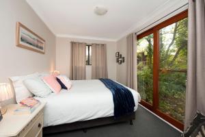 a bedroom with a bed and a window at Blue Starfish in Narrawallee