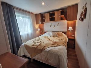 a bedroom with a bed with two birds on the wall at Mobil Home proche de la mer in Saint-Martin-Plage