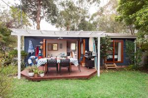 a small house with a table and chairs in a yard at Blue Starfish in Narrawallee