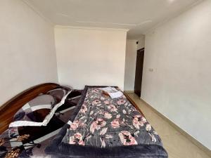 a bedroom with a bed in the corner of a room at Hotel Crescent in Srinagar