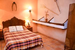 1 dormitorio con cama y estante en la pared en Casa Rural Las Tejas, en El Picazo
