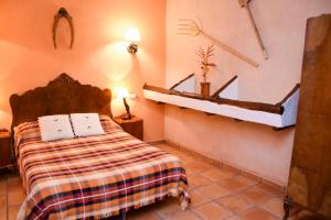 a bedroom with a bed and a shelf on the wall at Casa Rural Las Tejas in El Picazo