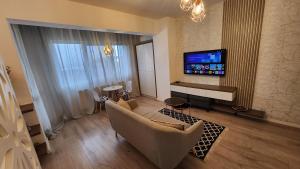 un soggiorno con divano e TV a schermo piatto di Garsoniera Argedava a Bucarest