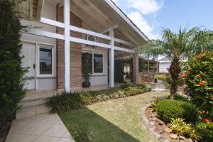 uma casa com um pátio e um quintal em Casa com churrasq, piscina e Wi-Fi em Criciuma SC em Criciúma