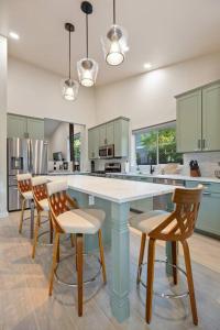 una cocina con una isla azul con sillas. en The Rock Trail House+Renovated+Modern+Fireplace+EV+Nice Yard en Flagstaff