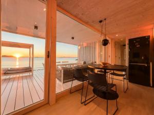 ein Esszimmer und ein Wohnzimmer mit Meerblick in der Unterkunft Buqez Eco Resort - Beach Villa 22 in Drage