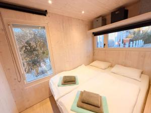 ein kleines Schlafzimmer mit einem Bett und einem Fenster in der Unterkunft Buqez Eco Resort - Beach Villa 22 in Drage + 28 Fotos