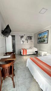 a hotel room with two beds and a desk at Pousada Praia Boa Viagem in Recife