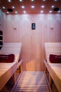 sauna z dwoma łóżkami piętrowymi i zegarem na ścianie w obiekcie La prestigieuse Sauna Balnéo Ciné w mieście Roannes-Saint-Mary