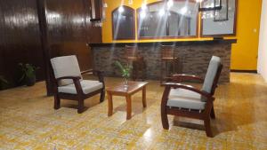 uma sala de estar com duas cadeiras e uma mesa em Hotel Sansívar em León