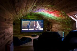 a living room with a tv and a ceiling with lights at La prestigieuse Sauna Balnéo Ciné in Roannes-Saint-Mary