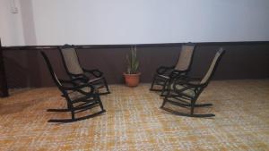 duas cadeiras pretas num quarto com uma planta em Hotel Sansívar em León