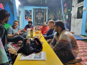 un grupo de hombres sentados alrededor de una mesa en Shanti guest house chojh en Kasol