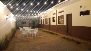 a patio with a table and chairs and lights at Hotel Sansívar in León