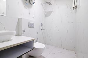 a white bathroom with a toilet and a shower at Hotel Bellwood Grand Near Delhi IGI Airport in New Delhi