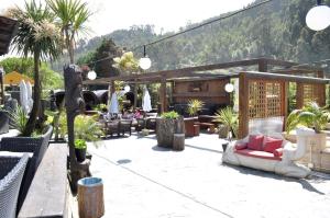 a patio with a couch and chairs and palm trees at Ak-55 Rural House in Villaviciosa