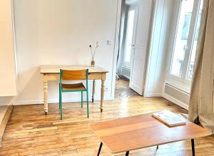 een tafel en een stoel in een kamer met een tafel bij Beautiful 1 bedroom in Le Marais in Parijs