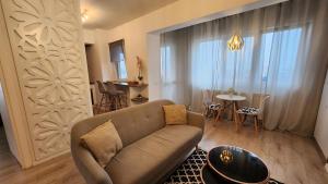 uma sala de estar com um sofá e uma mesa em Garsoniera Argedava em Bucareste