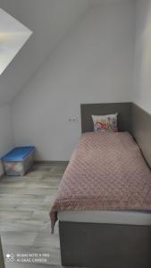 - une chambre avec un lit et une couette brune dans l'établissement Apartmán na Šumavě, à Vimperk