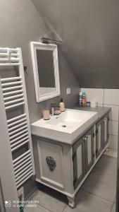 Apartmán na Šumavě في فيمبيرك: حمام مع حوض ومرآة