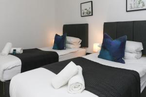 Zimmer mit 2 Betten und blauen und weißen Kissen in der Unterkunft Strawberry Line, Apartment 1 in Wells