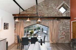 uma sala de jantar com uma parede de tijolos e uma mesa com cadeiras em Strawberry Line, Apartment 1 em Wells
