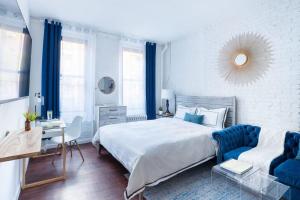 a bedroom with a large bed and a blue chair at 83-2FE UES Central Park Newly Furnished Studio in New York