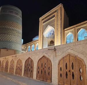 a building with wooden doors and two towers at Guest House Khiva BOYJON OTA in Khiva