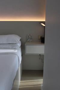 um quarto com uma cama com dois copos numa prateleira em 1 BR Luxury Apt by AJ Aljada em Sharjah