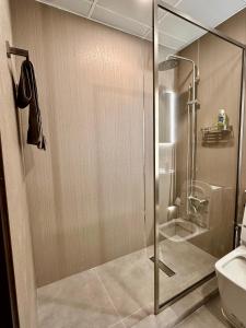 La salle de bains est pourvue d'une douche avec une porte en verre. dans l'établissement Silicon Path Spacious studio, à Dubaï