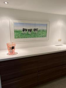 a painting of cows in a field on a wall at Beekzicht in Haaksbergen