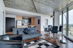 ein Wohnzimmer mit einem blauen Sofa und einem Tisch in der Unterkunft Les Immeubles Charlevoix - 760-212 in Québec