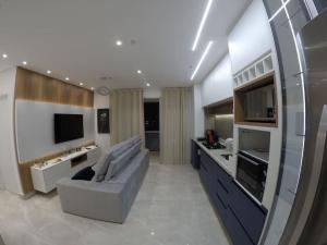ein großes Wohnzimmer mit einem Sofa und einem TV in der Unterkunft Apartamento inteiro aconchegante, ótima localização! in Osasco