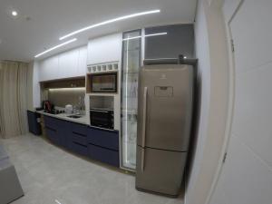 eine Küche mit einem Kühlschrank aus Edelstahl und blauen Schränken in der Unterkunft Apartamento inteiro aconchegante, ótima localização! in Osasco