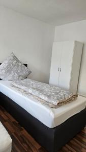 een bed in een kamer met een witte muur bij City Apartment Kehl in Kehl am Rhein