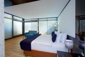 ein Schlafzimmer mit einem großen Bett und einem blauen Stuhl in der Unterkunft The Hera Platinum Hotel in Istanbul