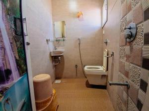 łazienka z toaletą i umywalką w obiekcie HK Inn w mieście Mandvi